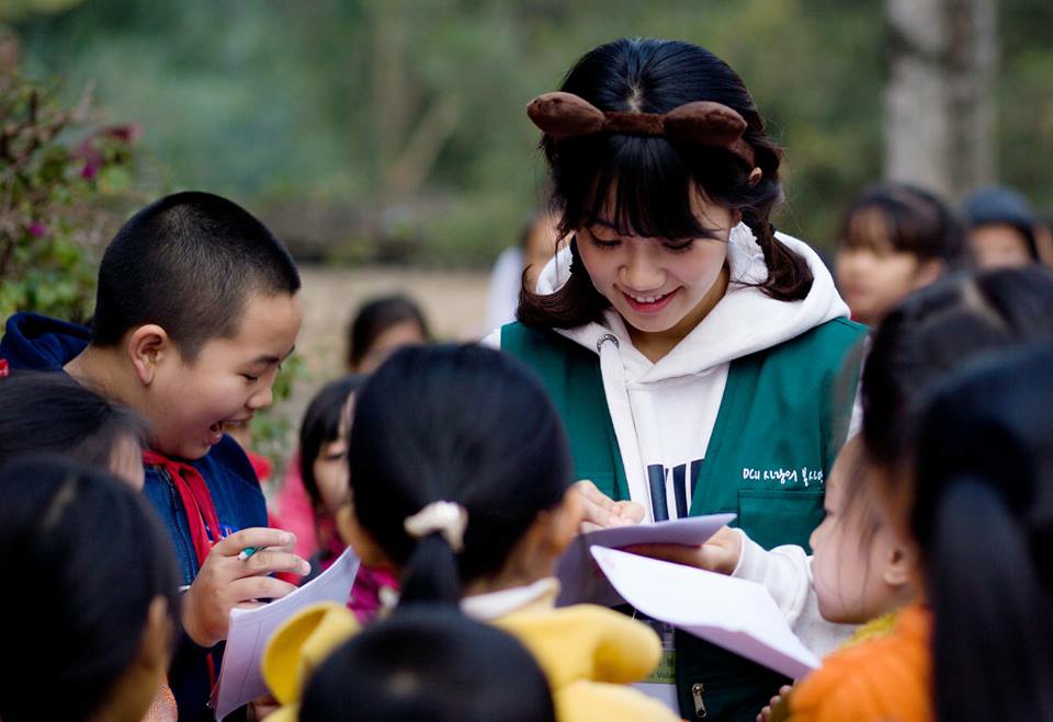 찌엔탕 초등학생들에게 둘러쌓여 싸인을 하고 있는 자원봉사단 사진